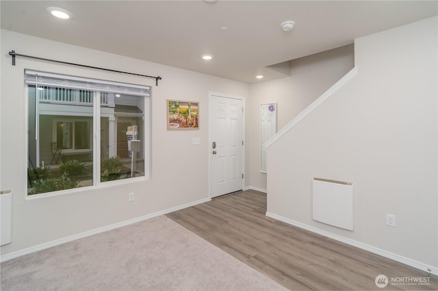 foyer featuring baseboards, wood finished floors, and recessed lighting