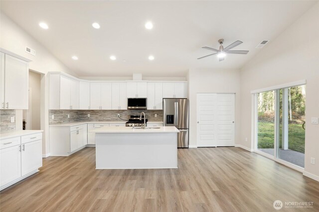10707 212th St E, Graham, WA 98338 - kitchen with visible vents, light countertops, vaulted ceiling, appliances with stainless steel finishes, and white cabinets