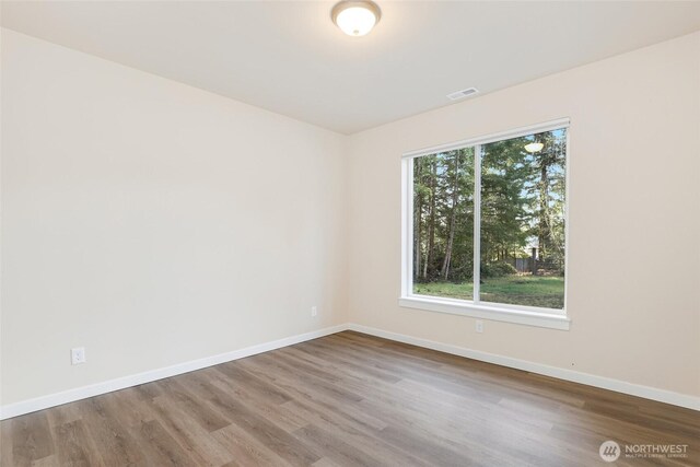 10707 212th St E, Graham, WA 98338 - empty room featuring visible vents, baseboards, and wood finished floors