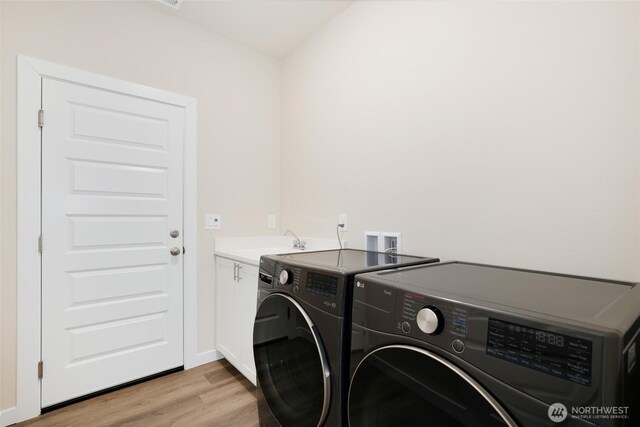 10707 212th St E, Graham, WA 98338 - laundry area featuring baseboards, light wood finished floors, cabinet space, a sink, and washer and clothes dryer