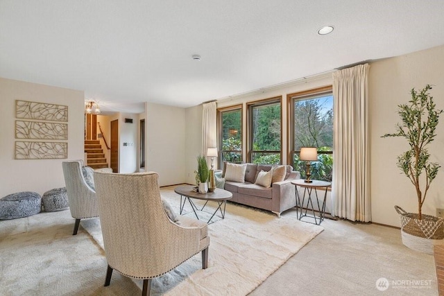 living area featuring light carpet, stairway, and baseboards