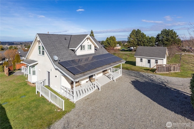 exterior space with a shingled roof, a front yard, gravel driveway, and covered porch