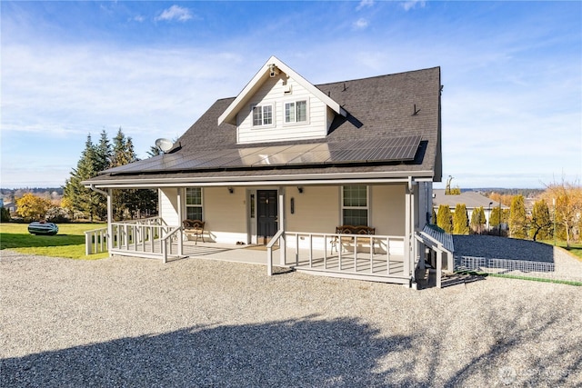 rear view of house featuring a patio area and roof mounted solar panels