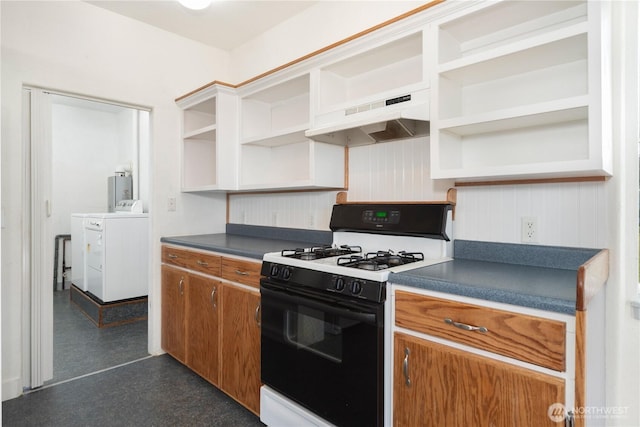 kitchen with under cabinet range hood, separate washer and dryer, open shelves, gas range oven, and dark countertops