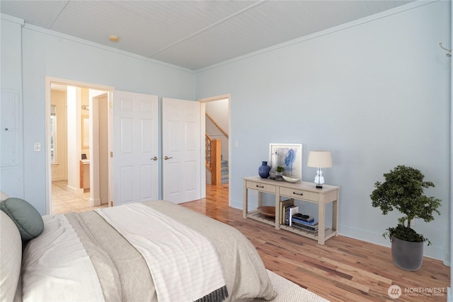 bedroom with light wood-style floors and ensuite bathroom