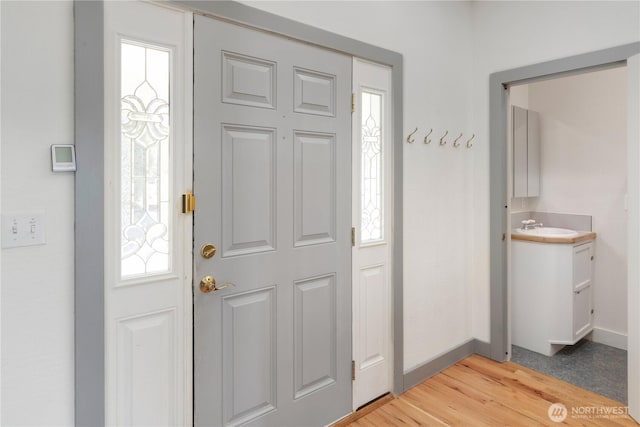 entrance foyer featuring light wood-style floors, a healthy amount of sunlight, and baseboards