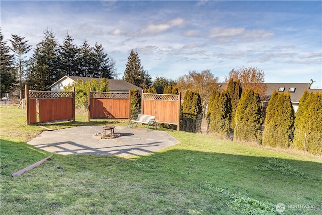 view of yard featuring a patio area, fence, and a fire pit