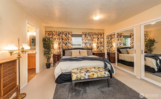 bedroom featuring a textured ceiling and light colored carpet