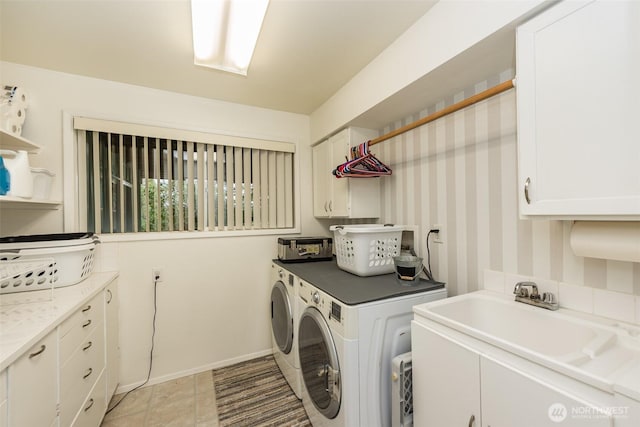 clothes washing area featuring separate washer and dryer, a sink, cabinet space, and baseboards