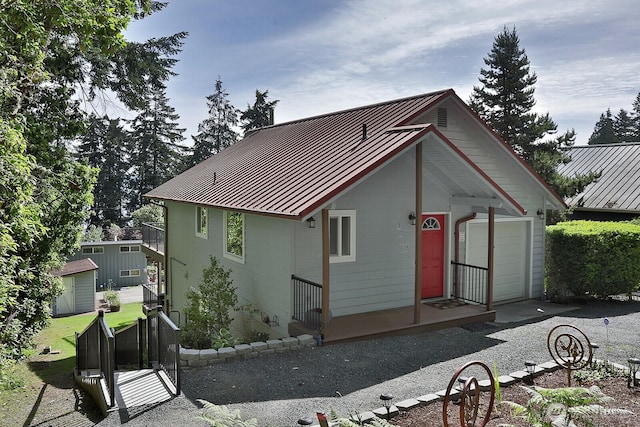 exterior space with a garage, a standing seam roof, and metal roof