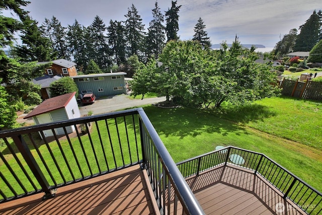 wooden deck featuring a lawn and an outdoor structure