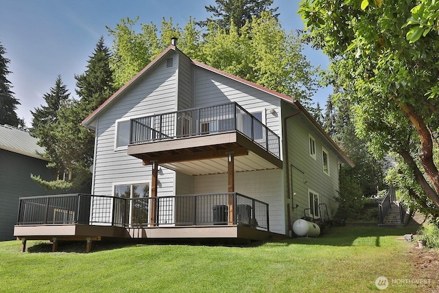 back of property featuring a balcony, central AC unit, and a yard