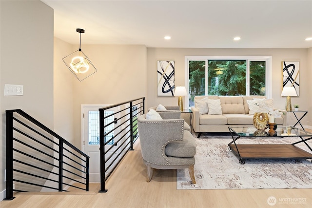 living area with a notable chandelier, recessed lighting, and wood finished floors