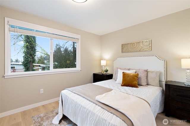 bedroom with baseboards and wood finished floors