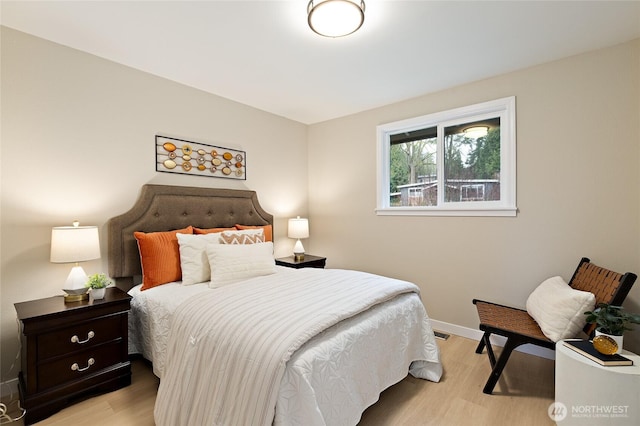 bedroom with light wood-type flooring, baseboards, and visible vents