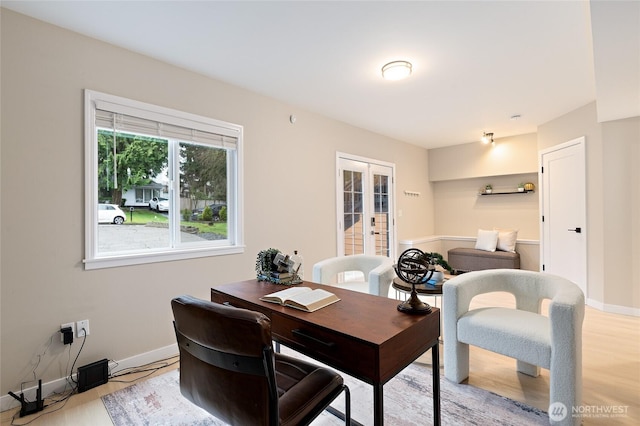 home office with french doors, baseboards, and light wood-style floors