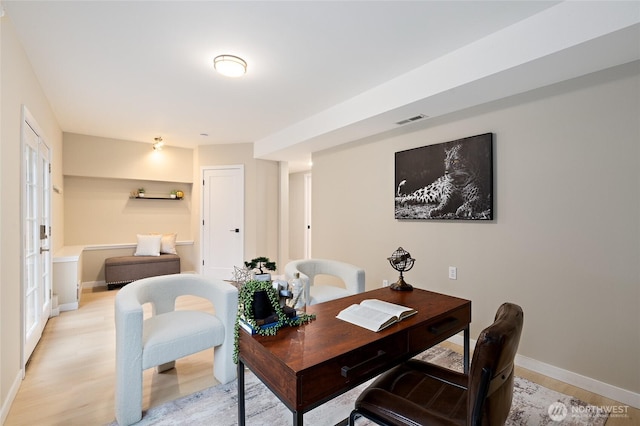 home office with visible vents, baseboards, and light wood-style flooring