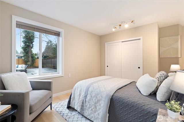 bedroom featuring light wood-style floors, a closet, and baseboards