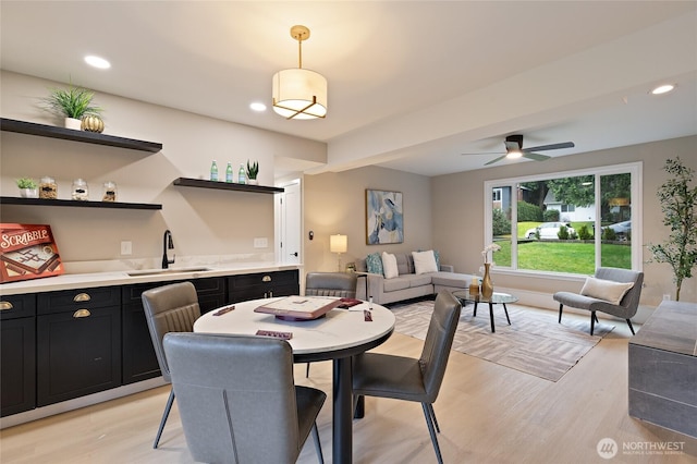 dining room with indoor wet bar, recessed lighting, light wood-style floors, and ceiling fan