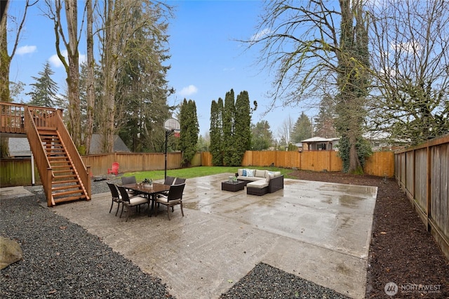 view of patio featuring outdoor dining space, stairway, a fenced backyard, and an outdoor hangout area