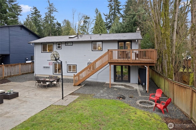 back of property featuring stairway, a wooden deck, an outdoor fire pit, a fenced backyard, and a patio area