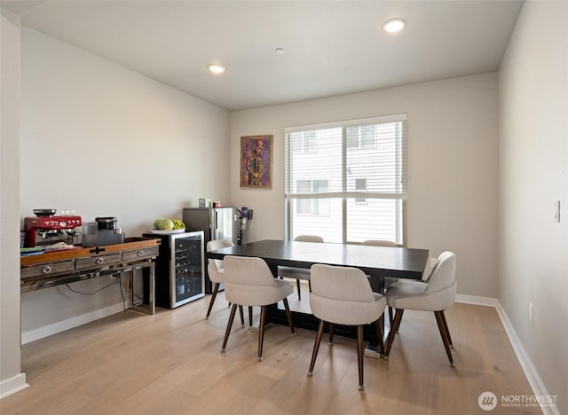 dining area featuring light wood-style floors, wine cooler, baseboards, and recessed lighting