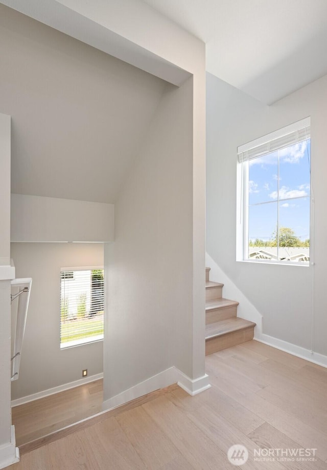 staircase with baseboards and wood finished floors