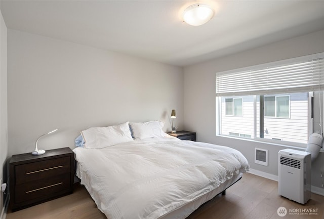 bedroom featuring wood finished floors and baseboards