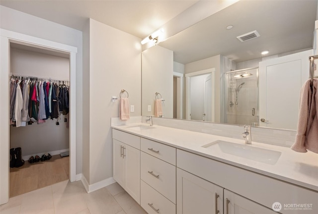 full bath with double vanity, a stall shower, visible vents, and a sink