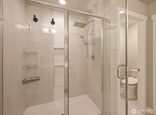 bathroom with a shower stall and toilet