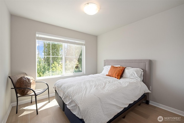 bedroom featuring baseboards and wood finished floors