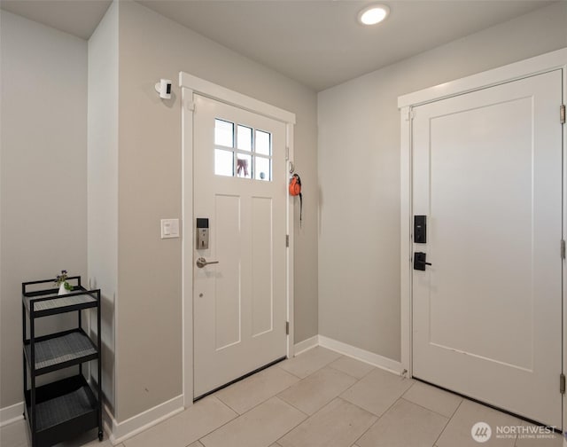 foyer with light tile patterned floors and baseboards