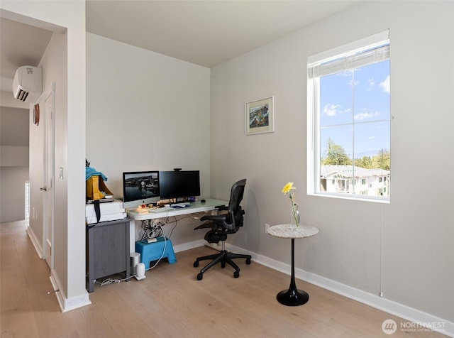 home office featuring a wall mounted air conditioner, wood finished floors, and baseboards