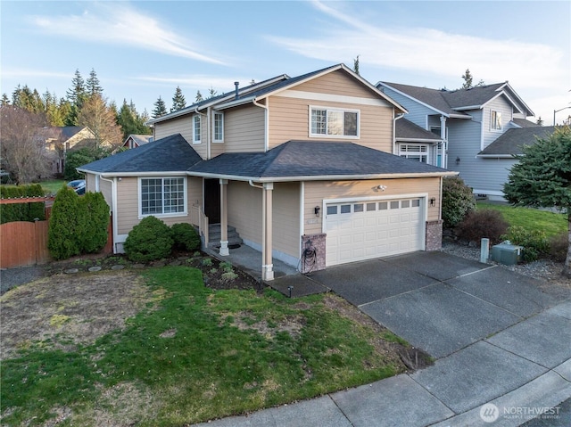 traditional home featuring a shingled roof, fence, a garage, driveway, and a front lawn