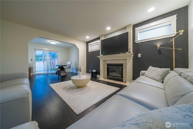 living room featuring recessed lighting, a tile fireplace, and wood finished floors