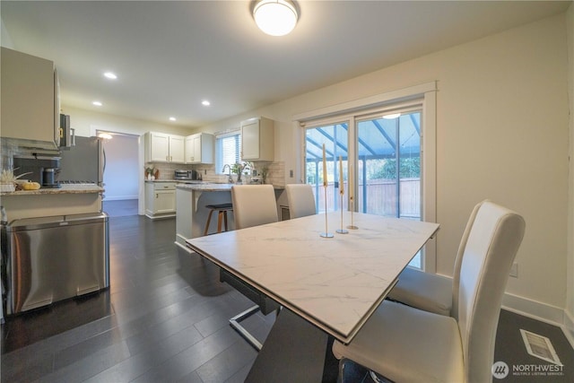 dining space featuring dark wood-style floors, recessed lighting, and baseboards