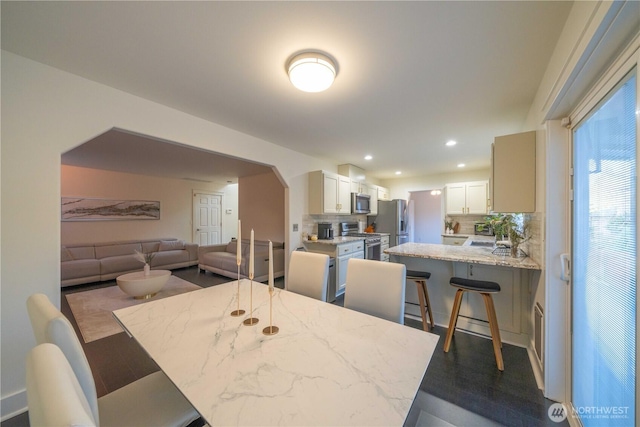 dining space with arched walkways and recessed lighting