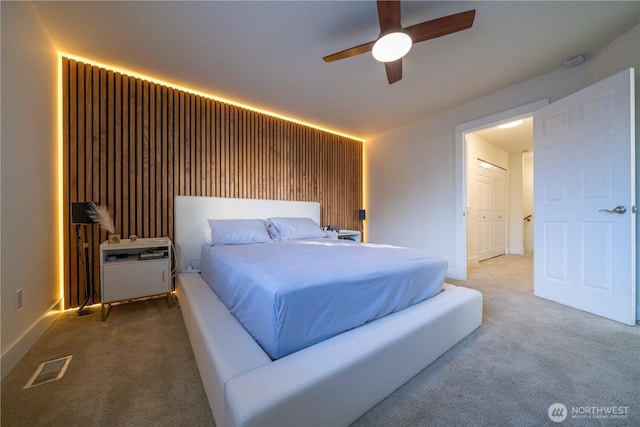 carpeted bedroom featuring ceiling fan and visible vents