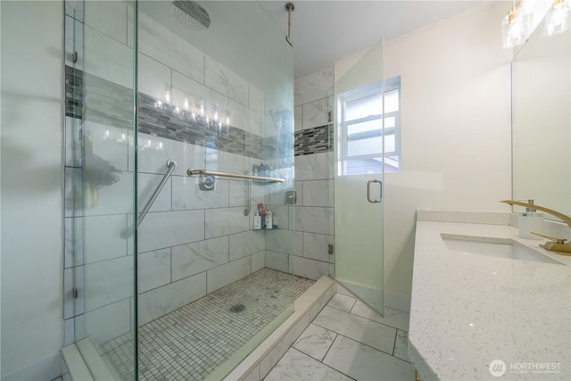 full bath featuring marble finish floor, a shower stall, and vanity