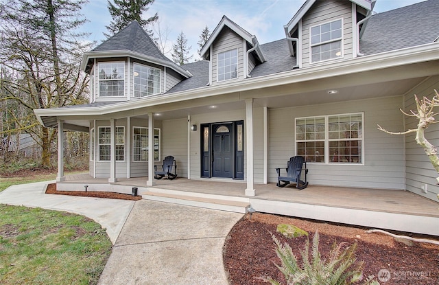 property entrance with a porch and a shingled roof