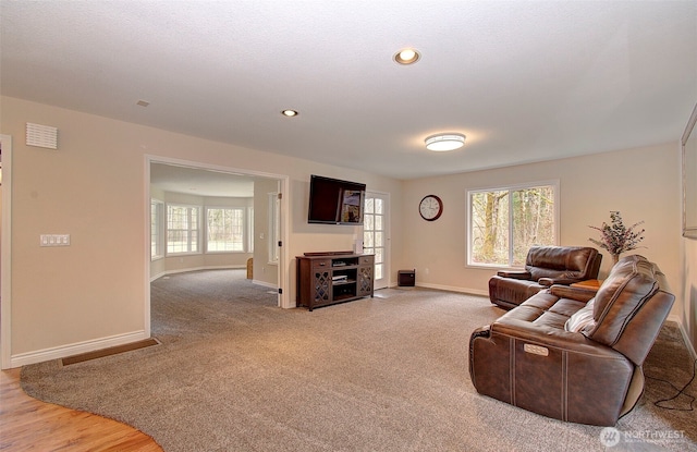 living area with recessed lighting, visible vents, baseboards, and light carpet