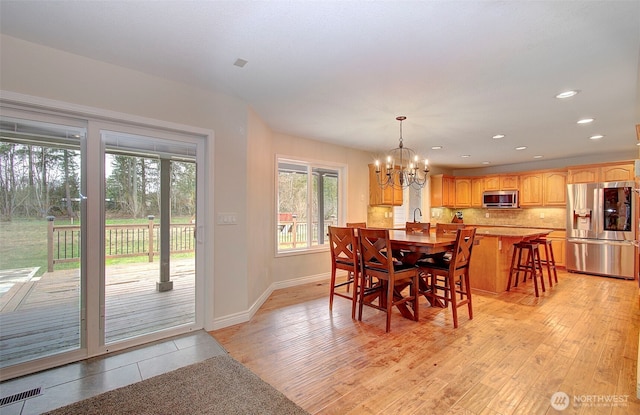 dining room featuring visible vents, baseboards, recessed lighting, light wood-style flooring, and an inviting chandelier