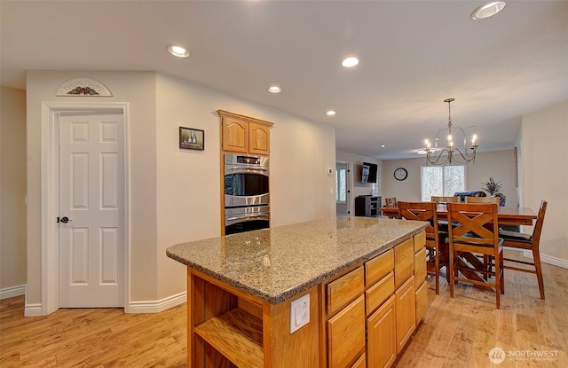 kitchen with open shelves, a kitchen island, recessed lighting, light wood finished floors, and light stone countertops