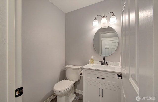 bathroom featuring baseboards, toilet, and vanity