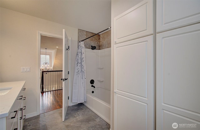 bathroom with baseboards, a notable chandelier, vanity, and shower / bath combination with curtain