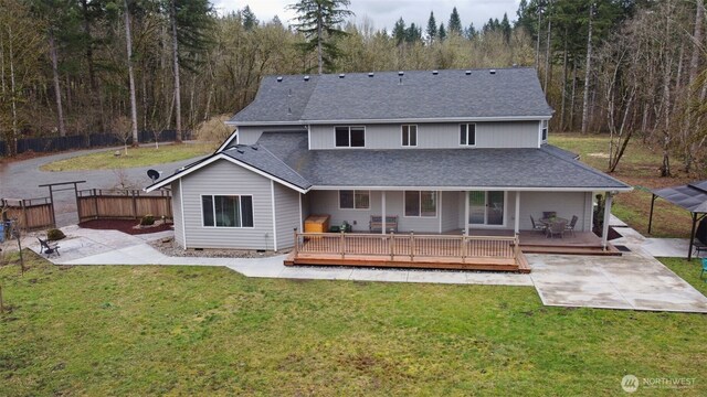 back of house with crawl space, a yard, a shingled roof, and fence