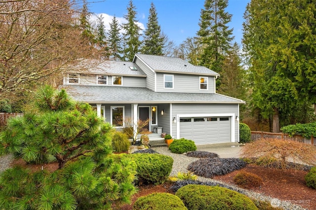 traditional home with a porch, an attached garage, fence, and a shingled roof