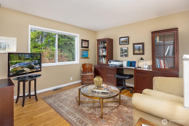 office with baseboards, visible vents, and light wood finished floors