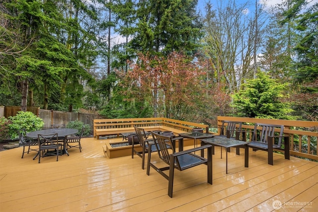 deck with outdoor dining space and fence