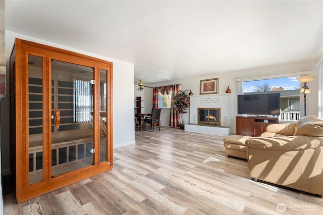 living room with a sauna, wood finished floors, and a fireplace